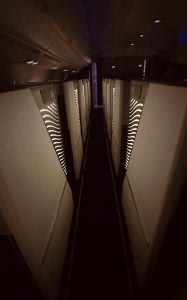 Quiet premium cabin aisle with soft lighting on a long-haul flight over Asia