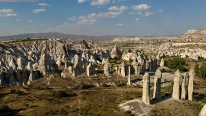 Panoramic view of Cappadocia fairy chimneys at golden hour.