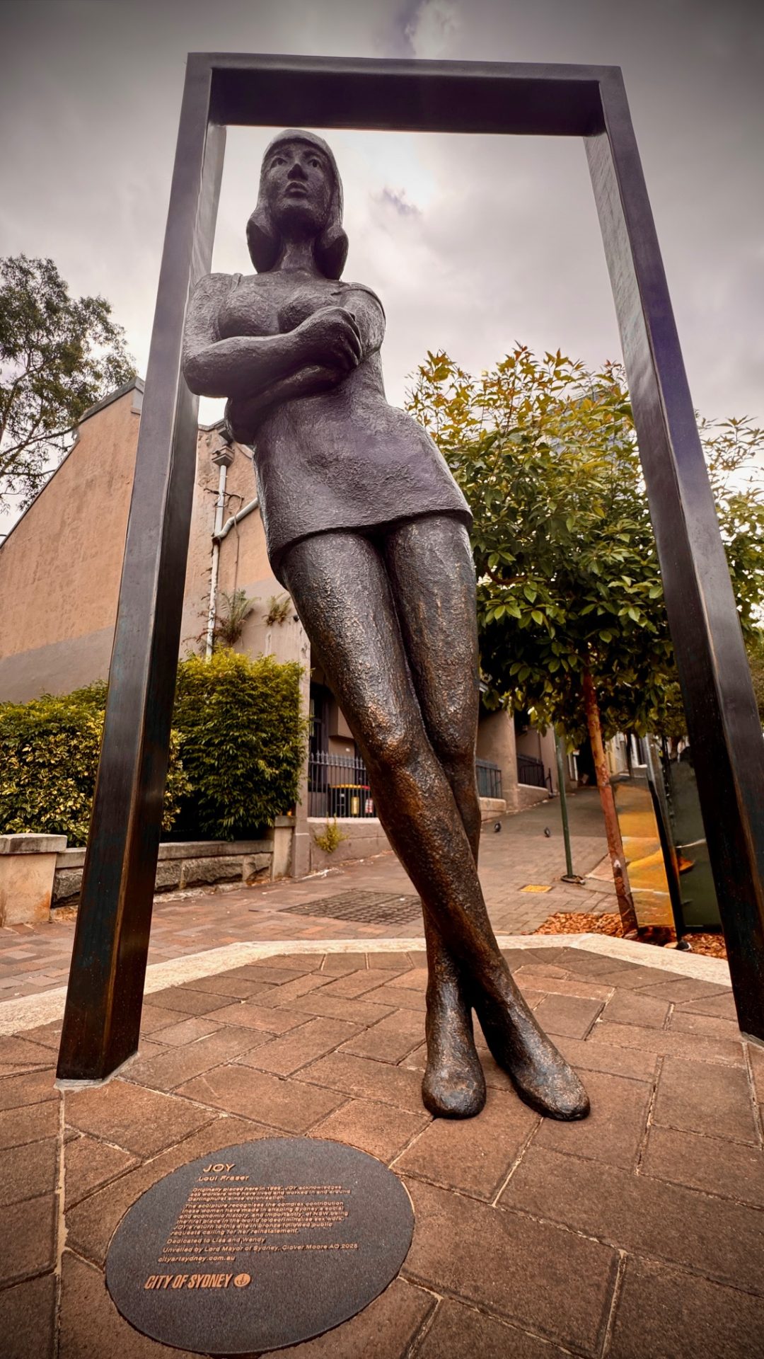 Bronze “Joy” statue of a sex worker leaning inside a rectangular frame in Darlinghurst, Sydney, Australia.