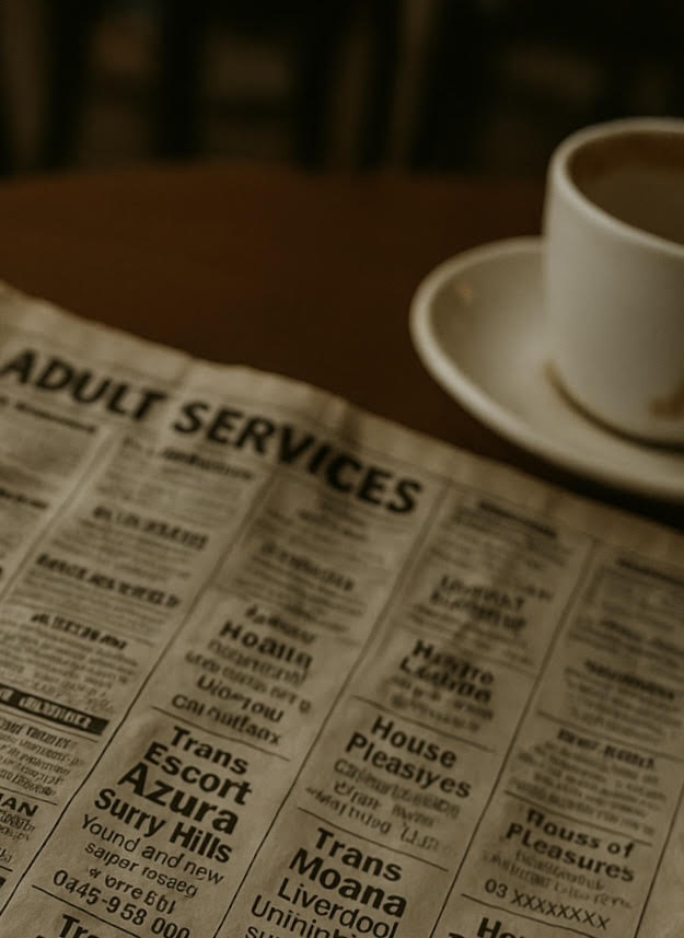 A vintage newspaper open to the classifieds section on a café table beside a coffee cup, evoking nostalgia and early advertising culture. 