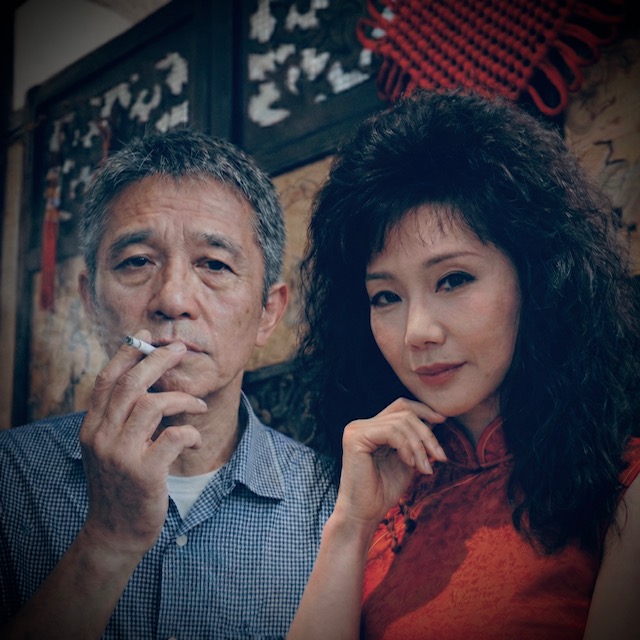 Vintage-styled portrait of an East Asian woman in a red cheongsam beside an older man smoking, evoking 1980s Hong Kong drama aesthetics.